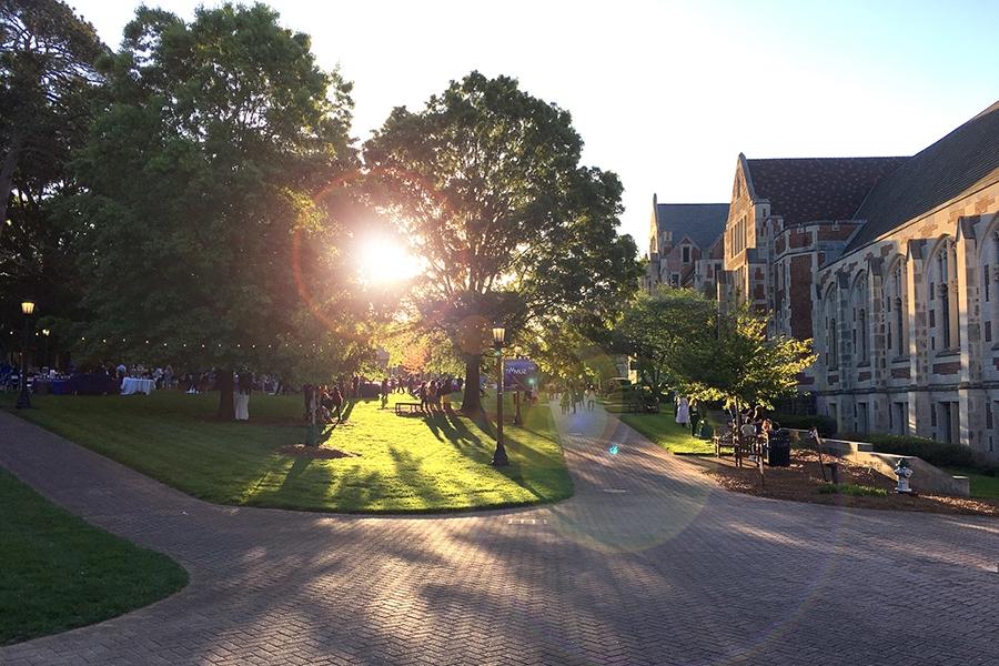 The evening pokes through the trees in front of Buttrick Hall.