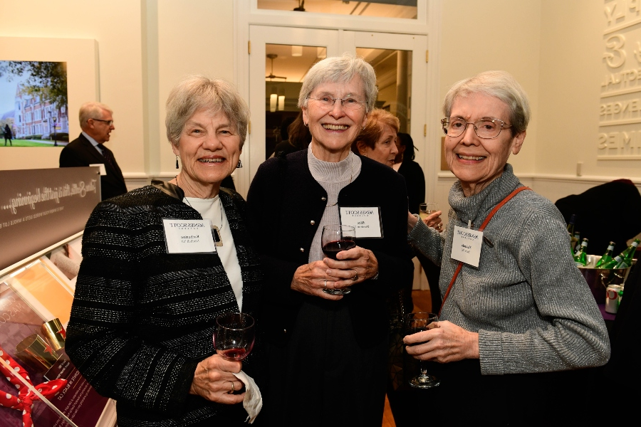 A group of women stand together for a photo with name badges.